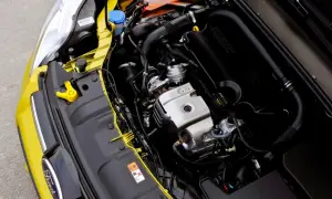 Silnik 1.0 Ecoboost w żółtym Fordzie. Widoczny jest czarny kolektor dolotowy z napisem "ECOBOOST" oraz metalowe elementy silnika.