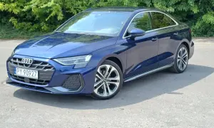 Elegancki, granatowy Audi A3 2025 sedan na tle zieleni.