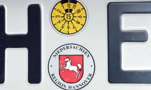 Niemieckie tablice rejestracyjne z herbem Dolnej Saksonii i naklejką przeglądu.