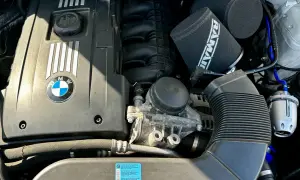 Silnik BMW e92 335i z dwoma stożkowymi filtrami powietrza RAMAI i niebieskimi przewodami.