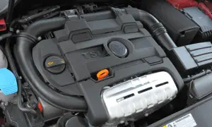 Silnik 1.4 TSI z widocznym logo VW. Widoczne elementy układu dolotowego i osłony silnika.