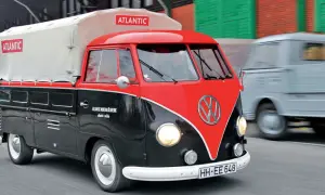 Klasyczny vw t1 w dwukolorowym malowaniu, z plandeką z logo "Atlantic", przemierza drogę.