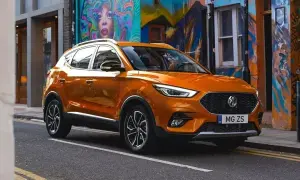 Pomarańczowe auto MG ZS na tle kolorowego muralu.