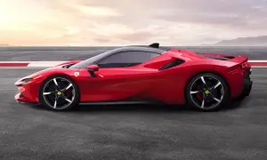 Czerwone Ferrari SF90 na torze wyścigowym, z czarnym dachem i felgami. Słońce zachodzi za górami.