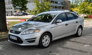 Srebrny Ford Mondeo MK4 2.0 TDCI zaparkowany na kostce brukowej przed budynkiem.