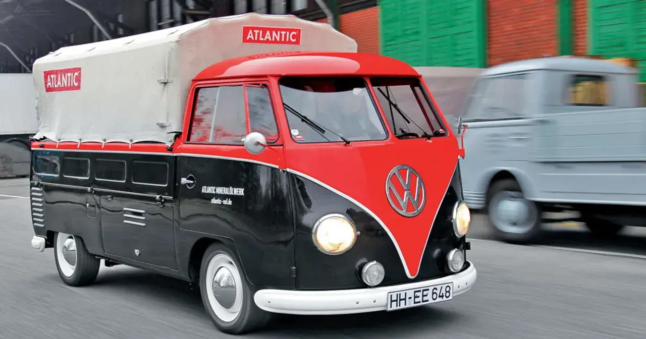 Klasyczny vw t1 w dwukolorowym malowaniu, z plandeką z logo "Atlantic", przemierza drogę.