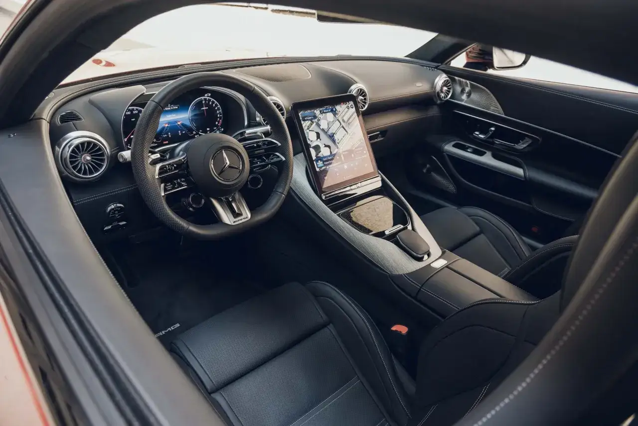 Wnętrze sportowego Mercedesa GT 63 AMG z nowoczesnym ekranem multimedialnym i cyfrowymi zegarami.