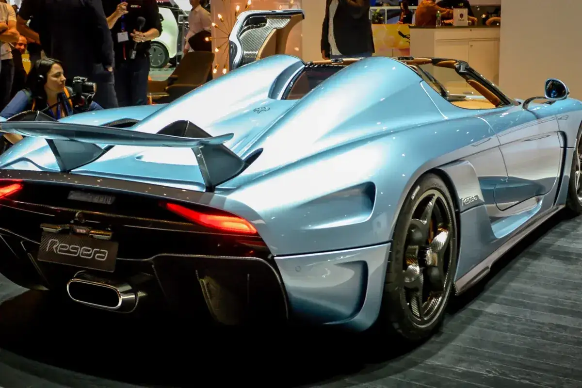 Błękitny Koenigsegg Regera z detalami z włókna węglowego i pomarańczowym wnętrzem.